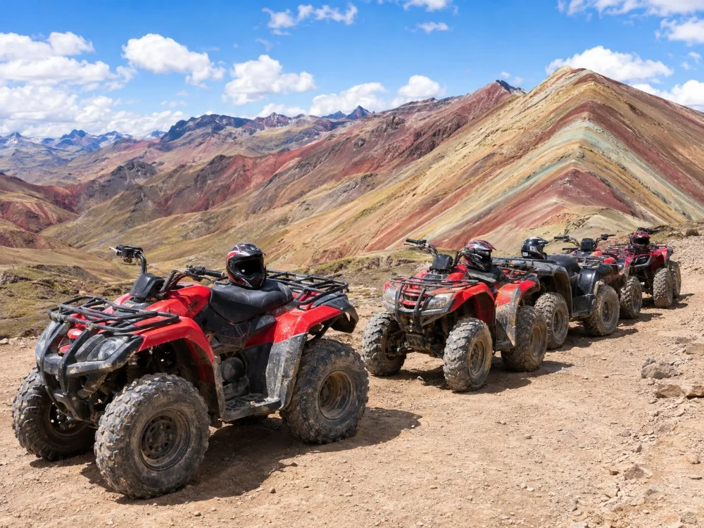 Quad-Bikes auf einer Schotterpiste unter roten und braunen Bergen abgestellt